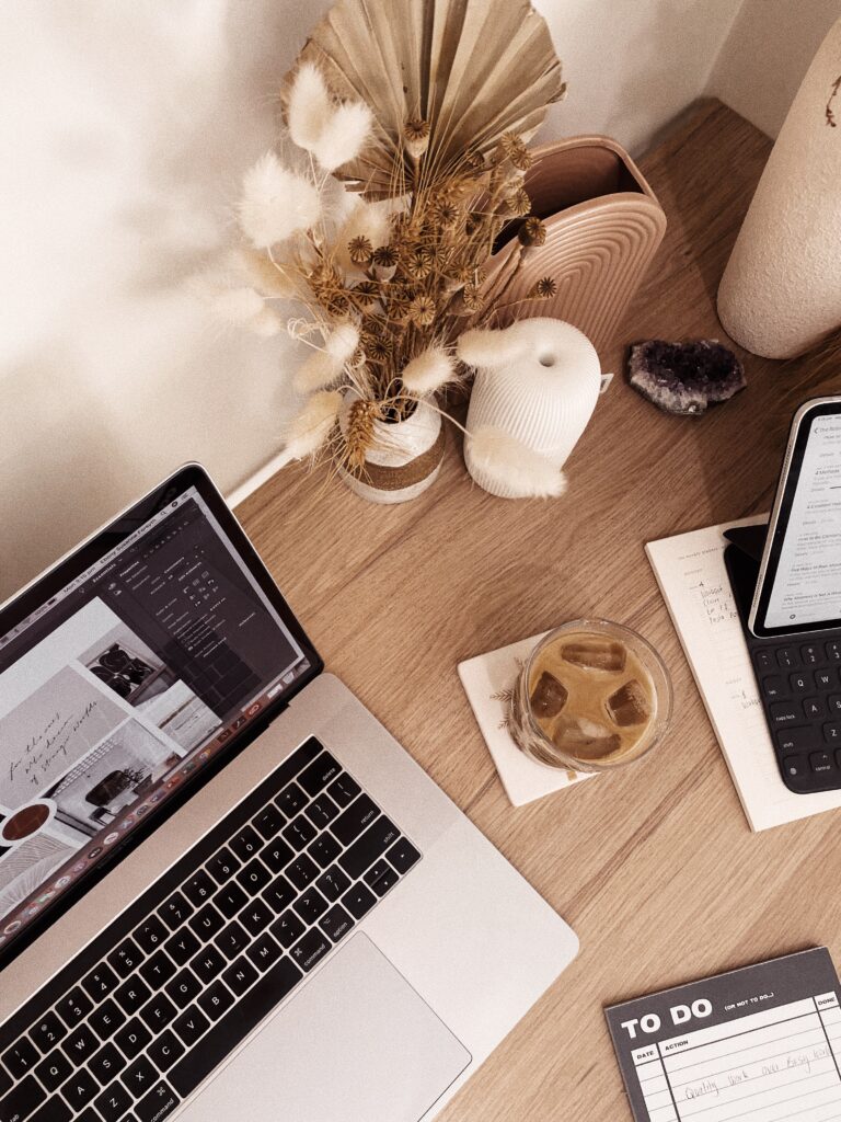 Clean white workspace with a modern monitor showing an Instagram profile, alongside a cup of tea and a wireless mouse, ideal for virtual assistants or content creators.